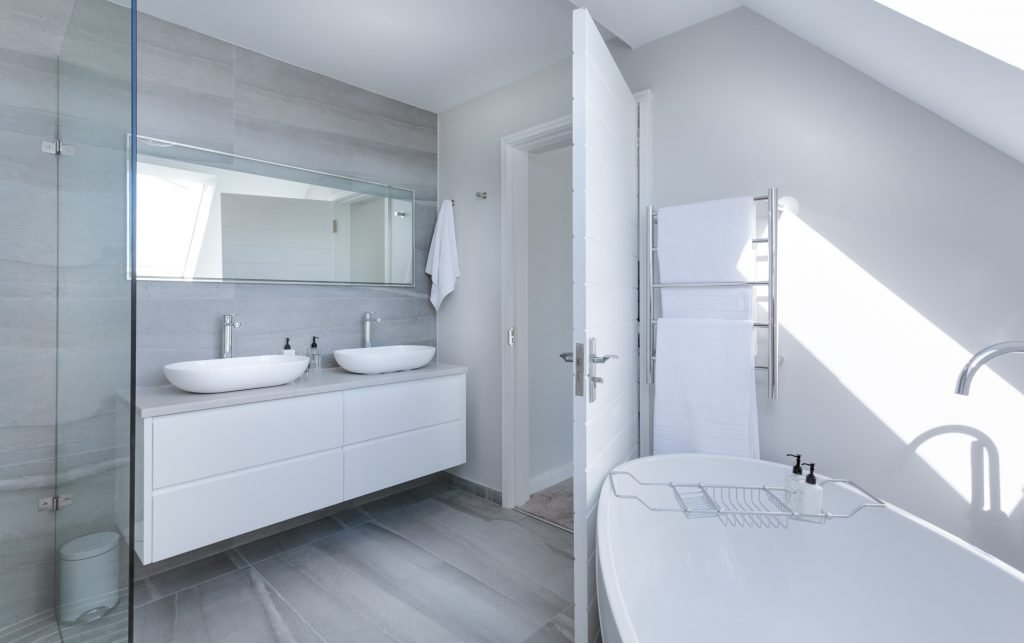 white bathroom with bath, sinks and glass shower - Noosa Plumber